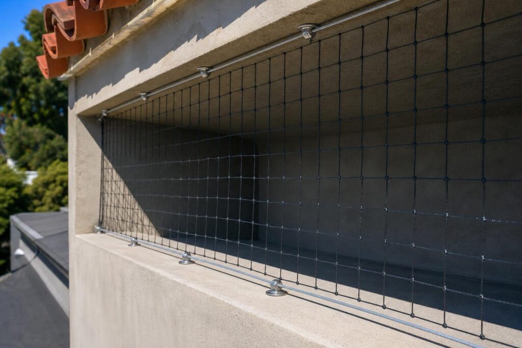 Professional pigeon netting installation on building ledge and beam in Brawley California